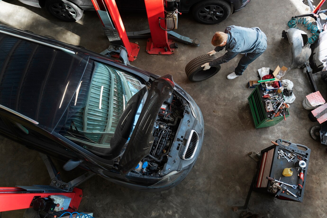 Mecanic lucrând la motorul unei mașini în atelier